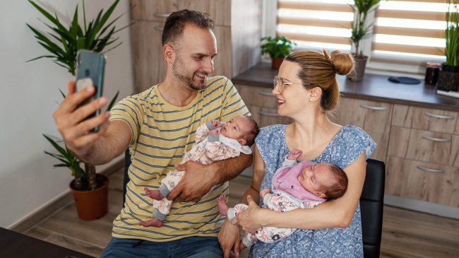 a mother and father holding their twins while doing their own baby photoshoot as a family
