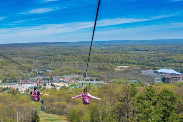 two people racing down a zipline