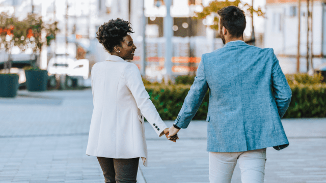 a couple holds hands as they walk through the city, one of the best date night ideas in Atlanta for parents
