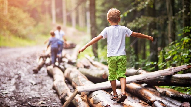 boy walking on logs