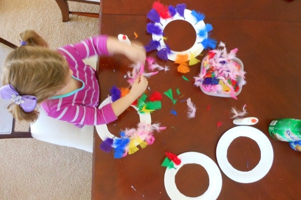 A little girl sits at a table playing a Thanksgiving ring toss game