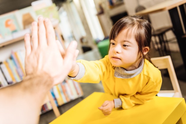 A disabled child gives her teacher a high five