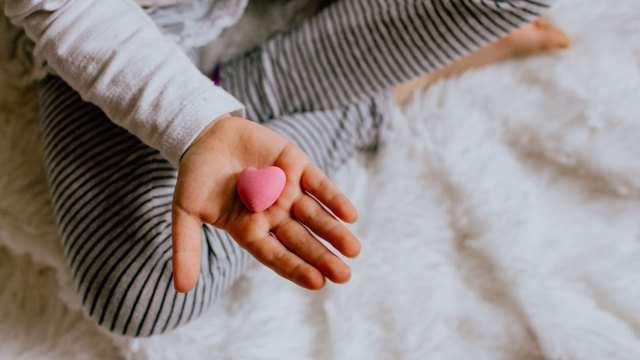Kid holding a heart.