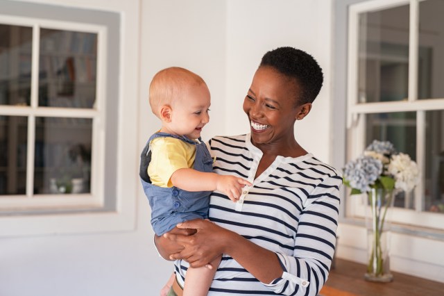 smiling Black mom with white baby - money-saving tips