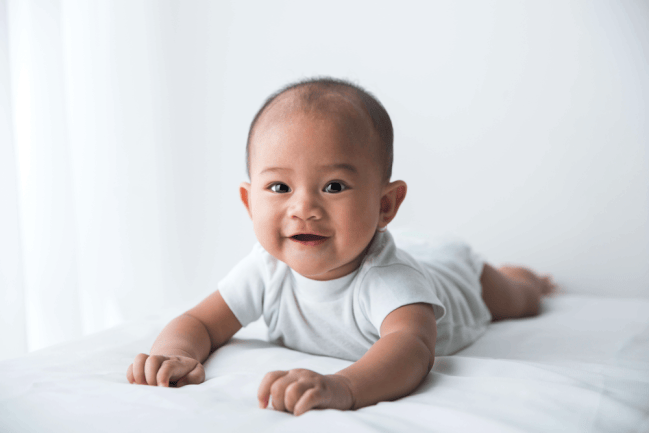 a baby lying on the floor doing tummy time