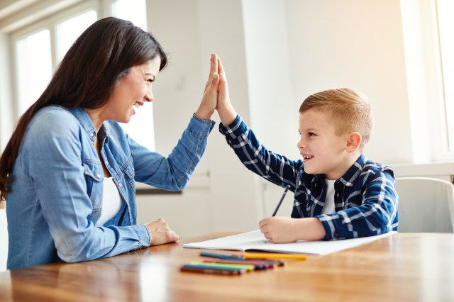 A teacher high fives a student in class