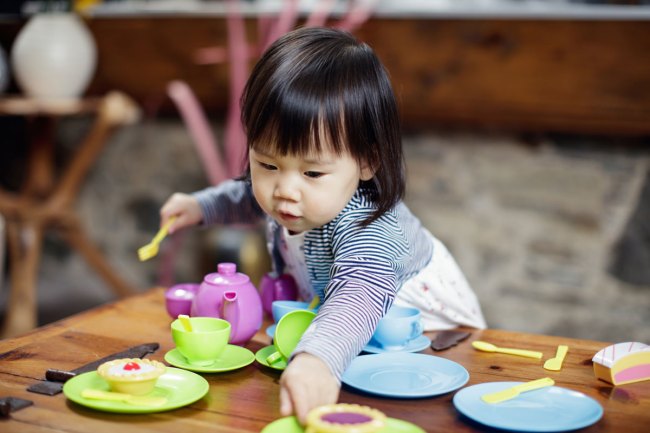 toddler girl playing pretend tea