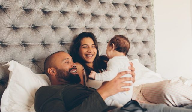 two parents holding baby on bed, italian court ruling kids last names