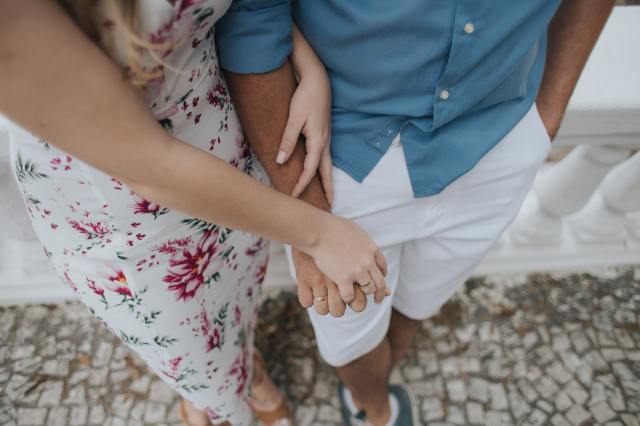 woman and man holding hands wedding bands