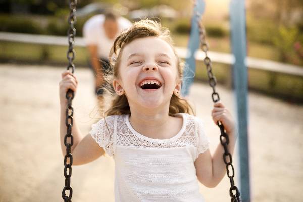 A girl laughs at a joke on a playground