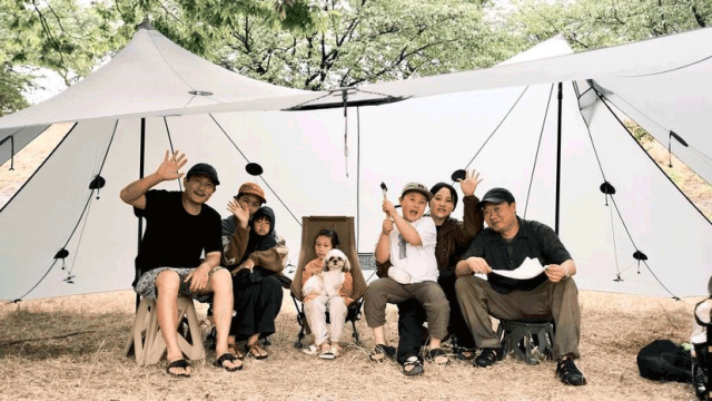 Family enjoying camping under a sun shade