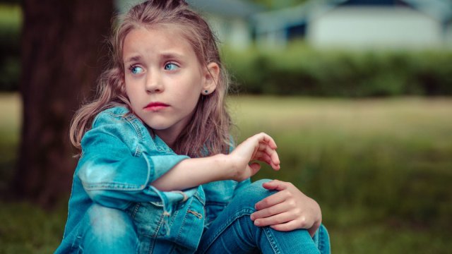 An anxious kids sits and worries.