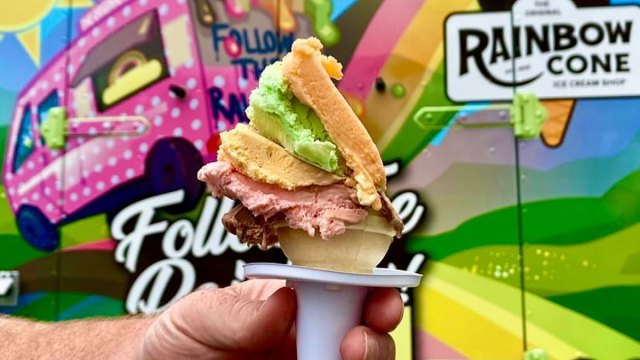 Hand holding rainbow ice cream cone