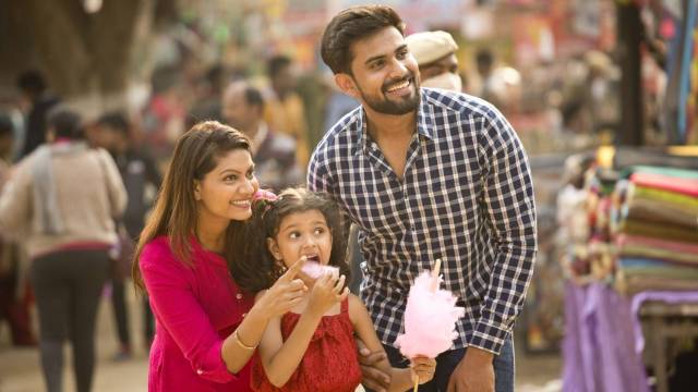 a family enjoys cotton candy as they wander a fall fairs and festivals events