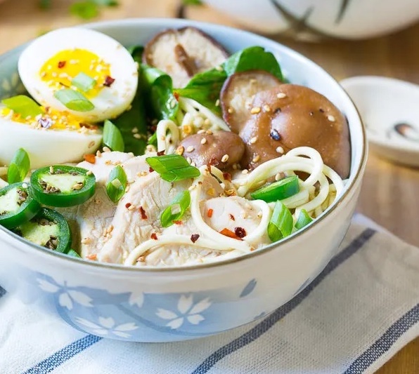 A bowl of chicken ramen made in a slow cooker and topped with eggs