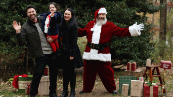 Santa poses outdoors with a family during a private Santa photo experience in New York City.