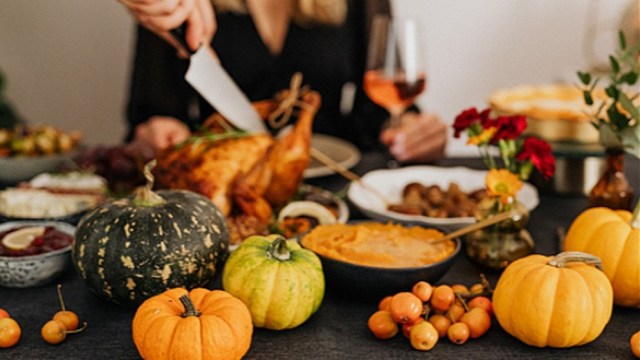 a woman carves a turkey for thanksgiving dinner