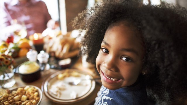a smiling girl at eating thanksgiving dinner in atlanta at a restaurant