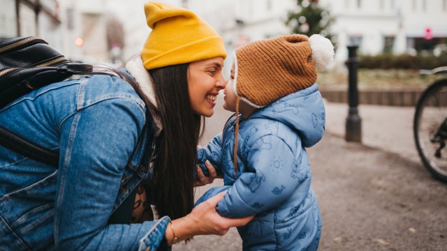 woman snuggling toddler in winter outside