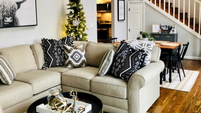 a cozy couch with a christmas tree behind it at a cabins in atlanta ga rental