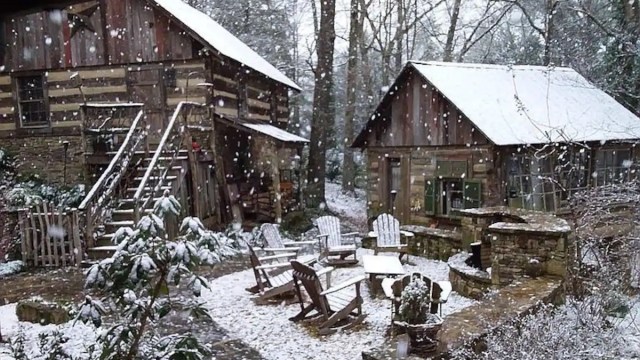two cabins near atlanta are covered in snow and there's a firepit and chairs in between the two mountain cabin rentals