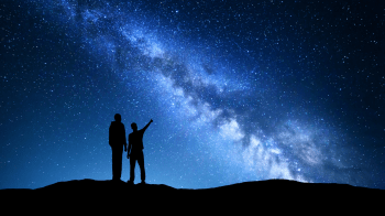 father and son learning space trivia for kids while looking at the milky way