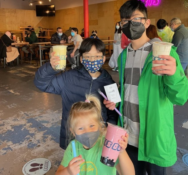 Three kids drinking boba tea in seattle chinatown international district