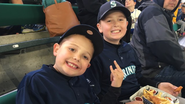 Two boys enjoy food in the stands at T Mobile Park