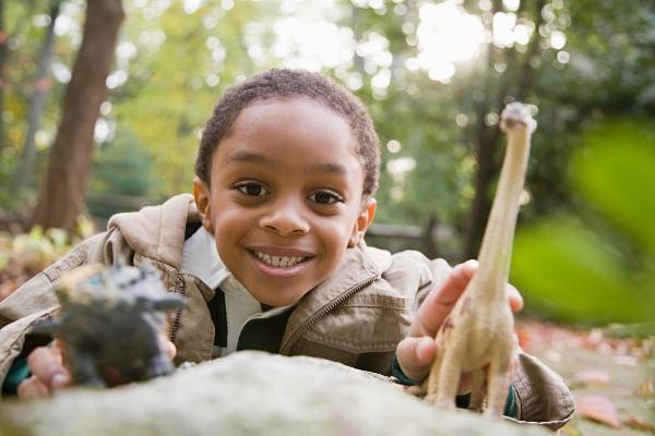 A boy plays with a toy giraffe