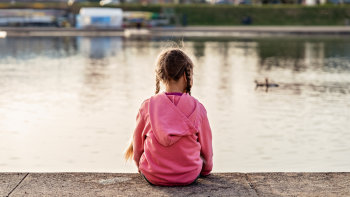 little girls sitting by a pond