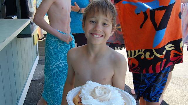 a boy eats an elephant ear at wild waves theme park