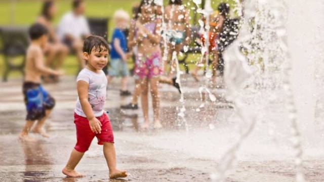a boy walks through a spray park splash pad outdoor activities seattle