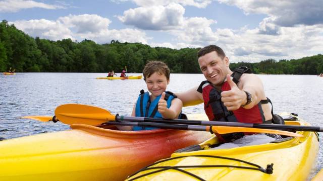 A dad and son kayak during a favorite outdoor activities seattle