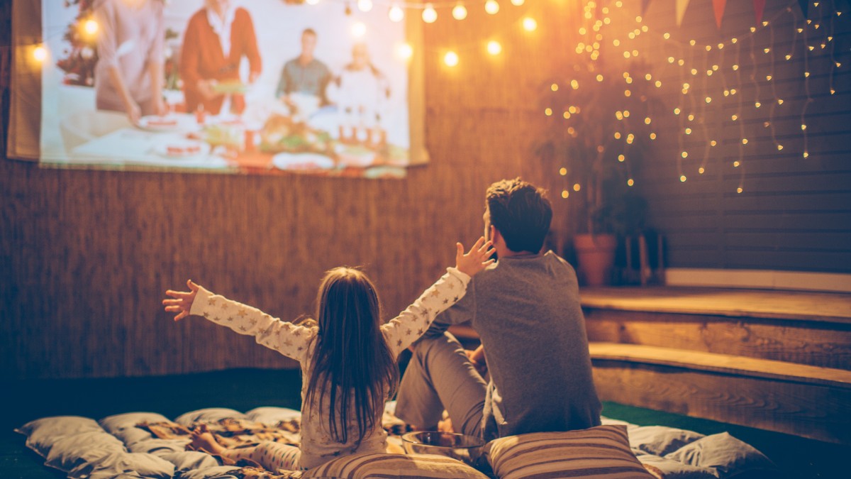 kids watch an outdoor movie during summer activities for preschoolers in the backyard