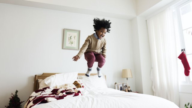 boy jumping on bed