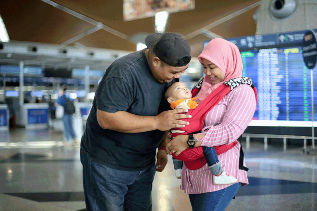 family with a baby in a carrier at the airport