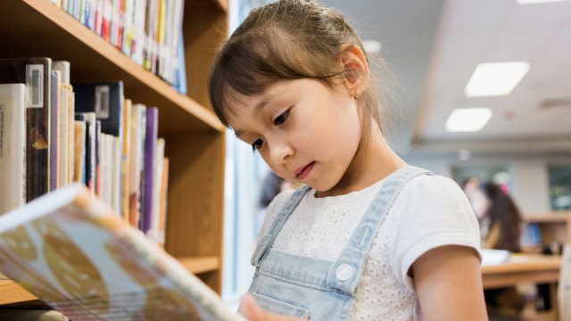 girl reading a book in the library