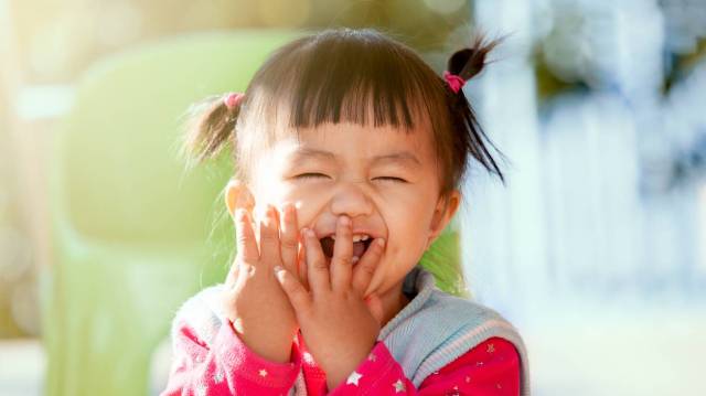 a girl with pigtails giggles