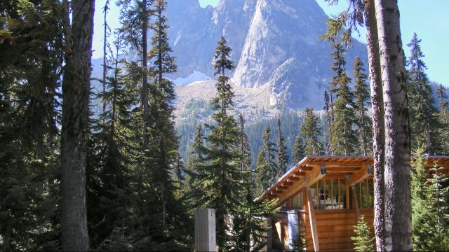 washington state parks cabin with tall trees and mountains surrounding it