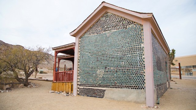 Ghost town scene with restroed building structure in pink and brown.