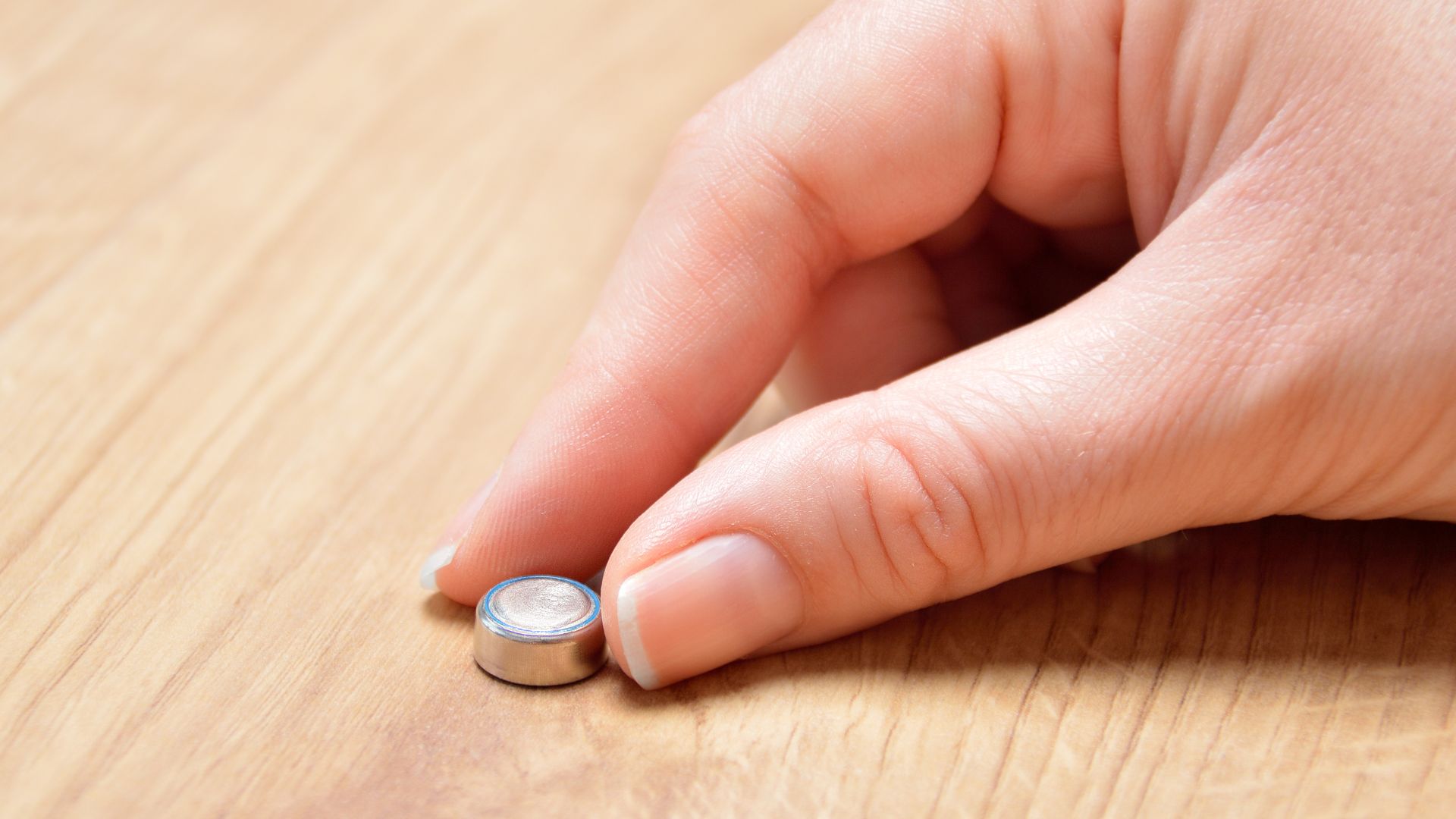 a hand holding button batteries