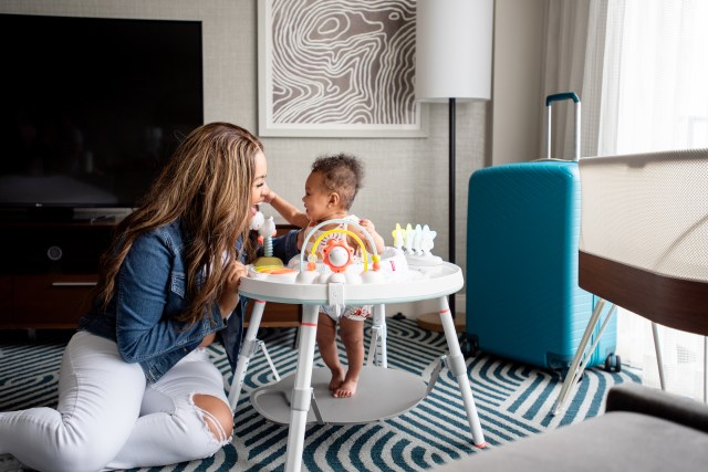 mother and baby in bouncer playing on floor