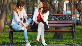 two women sitting on a bench