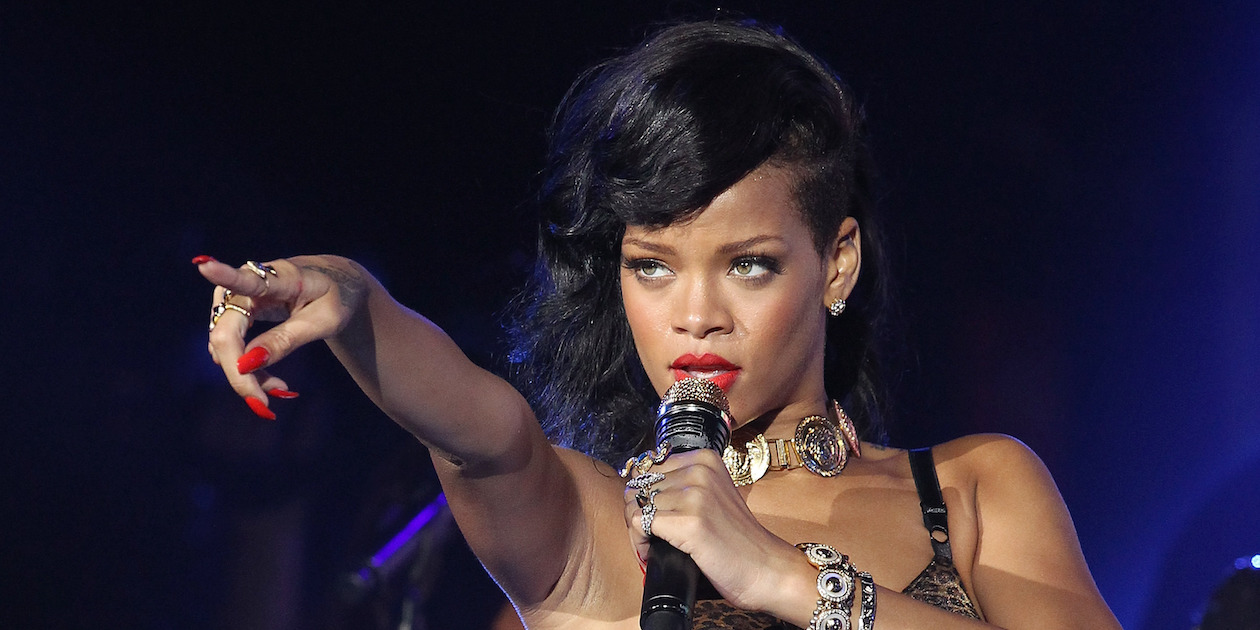 Rihanna performs onstage in a black outfit