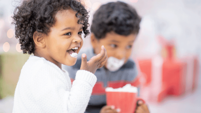 a girl licks whip cream from her cup at one of the best hot chocolate in boston spots