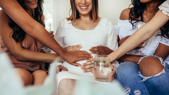hands touching pregnant woman's belly