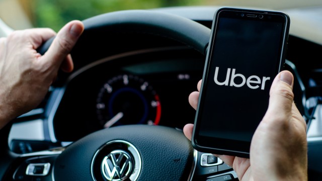 Uber driver holding smartphone in Volkswagen car
