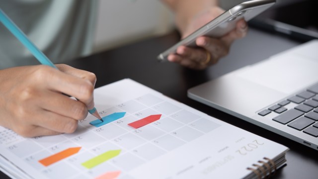 hand writing dates in a calendar planner