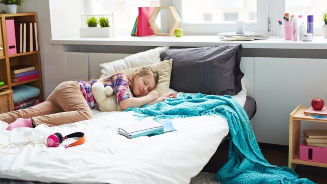 teen girl lying in messy bed and refusing to clean