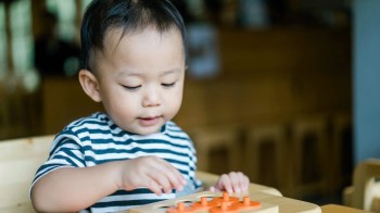 a child plays a game at the table while waiting for food, waiting games for kids